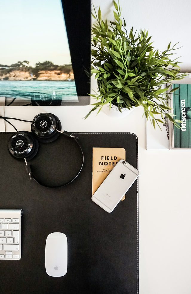 Headphones beside a smartphone on a desk