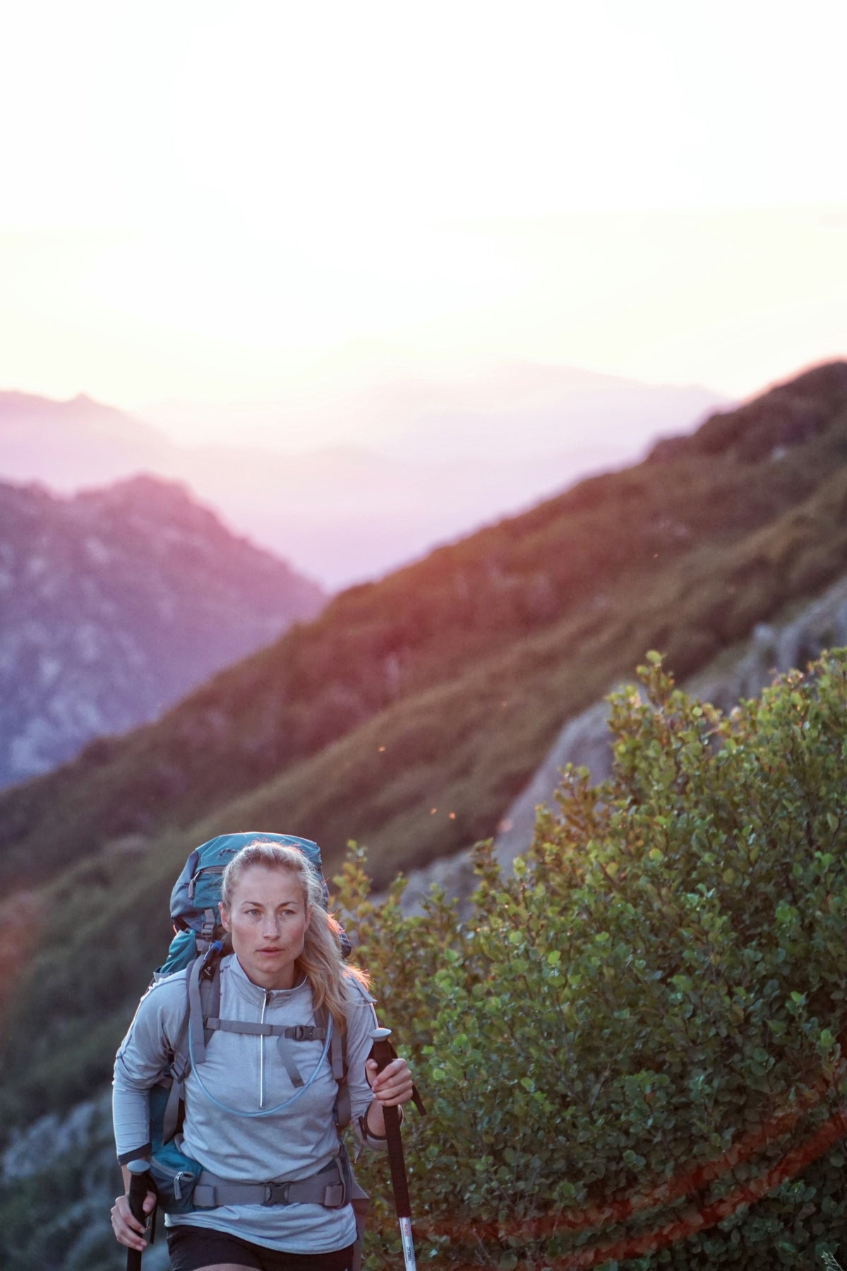 Woman hiking on mountain at golden hour