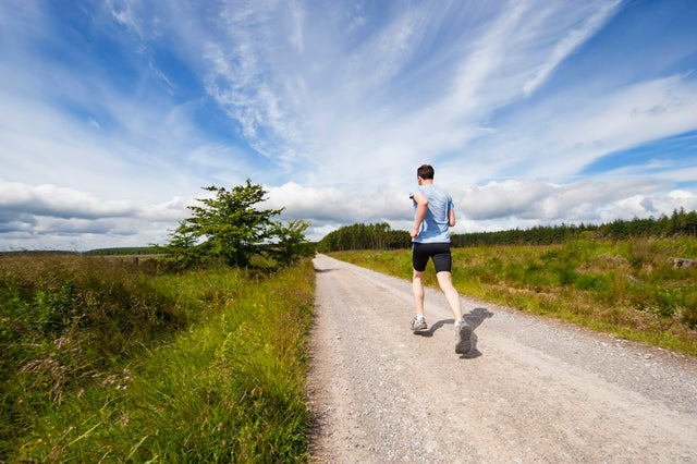 Man running on a countryside gravel road under a blue sky, illustrating how long TRT takes to work