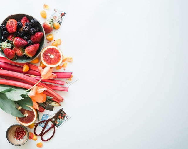 Fresh fruit and vegetables arranged on a white surface