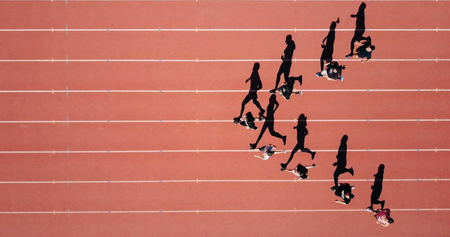 Aerial view of runners on a red track, representing VO2 max and fitness as key longevity biomarkers