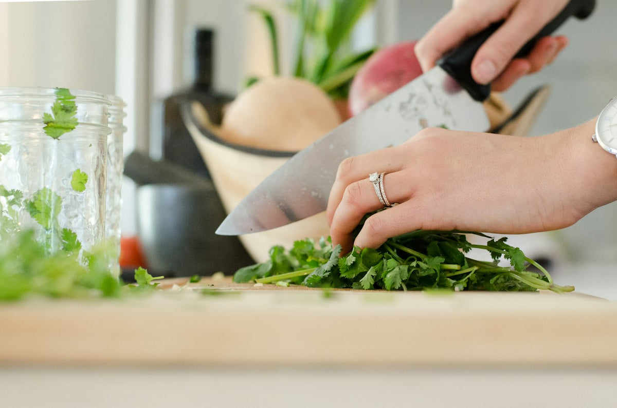 Person chopping fresh cilantro in a bright home kitchen, illustrating healthy routines alongside learning about retatrutide half-life