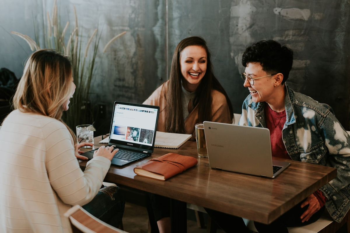 Group of people working together at laptops in a collaborative setting