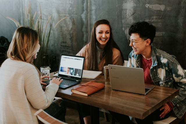 Group of people working together at laptops in a collaborative setting