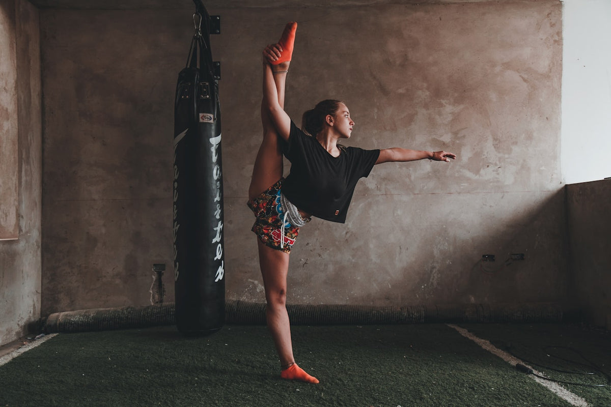 Woman doing a split while standing, representing flexibility and wellness