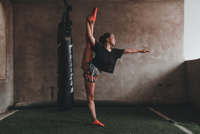Woman doing a split while standing, representing flexibility and wellness