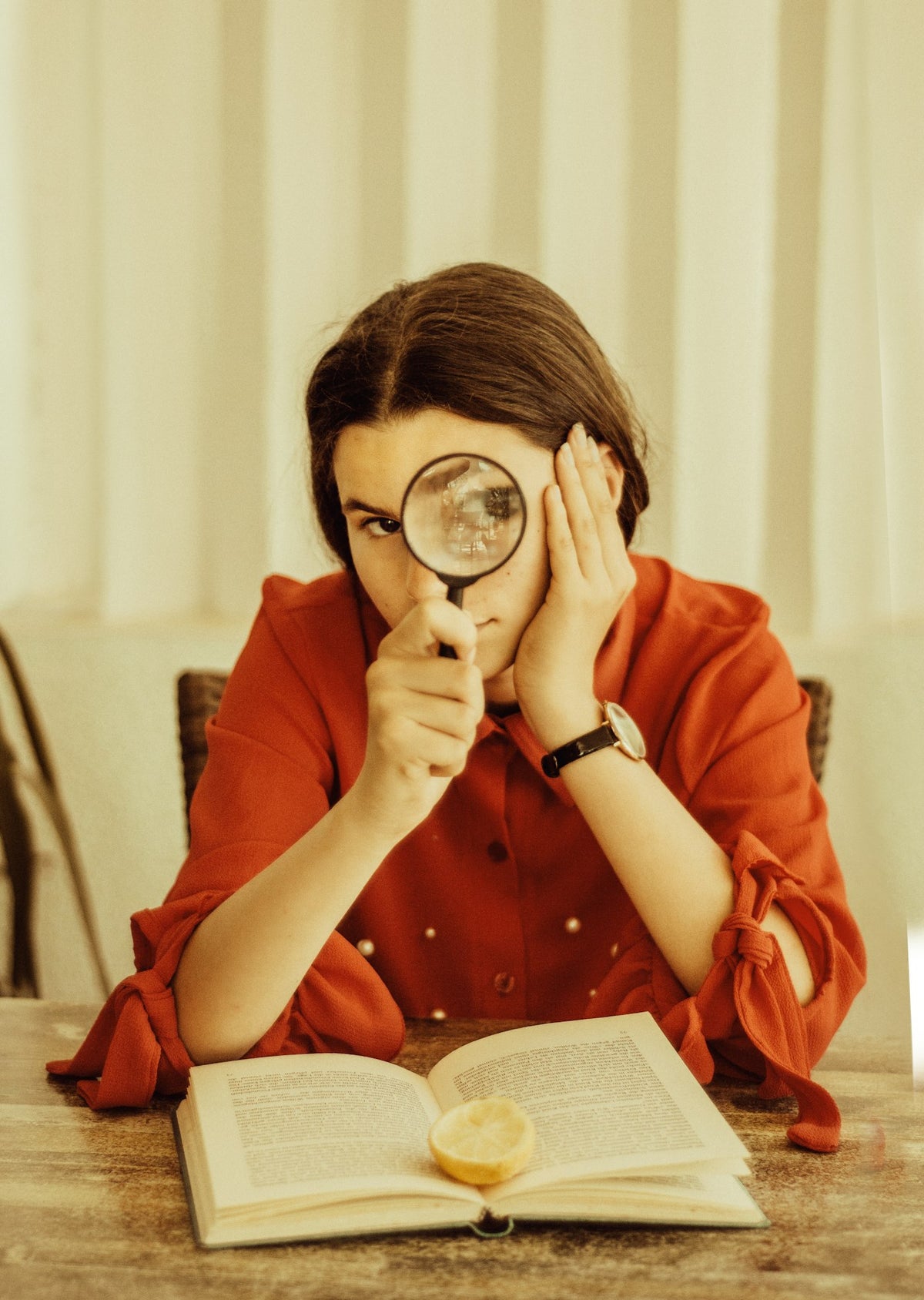 Woman holding a magnifying glass, researching options