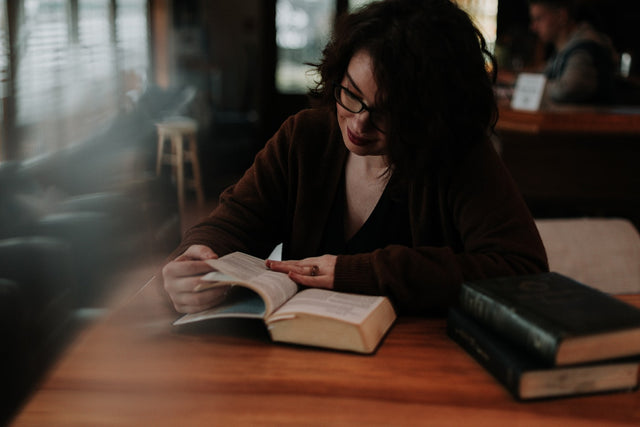 Woman reading a book while researching options