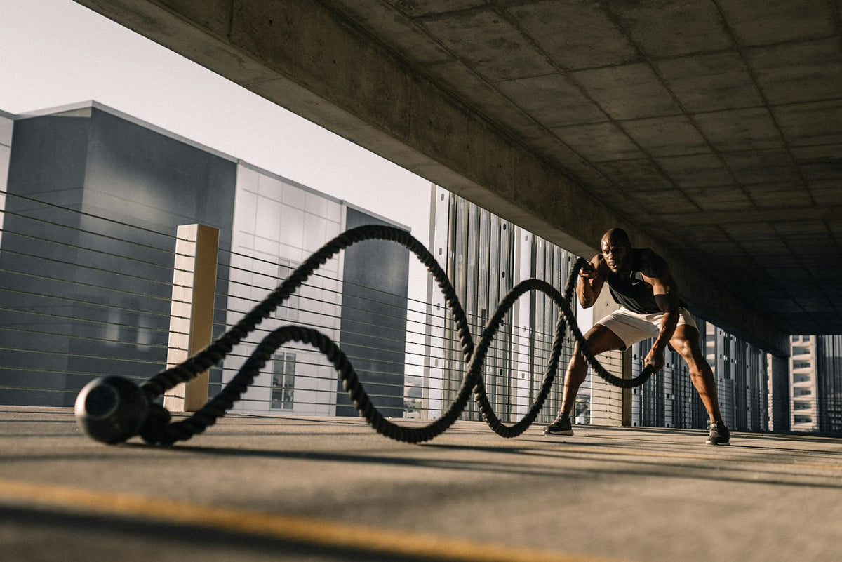 Man training with battle ropes outdoors, illustrating body composition and muscle in the sermorelin for weight loss discussion