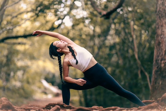 Woman in activewear doing a yoga pose during daytime, representing fitness and wellness