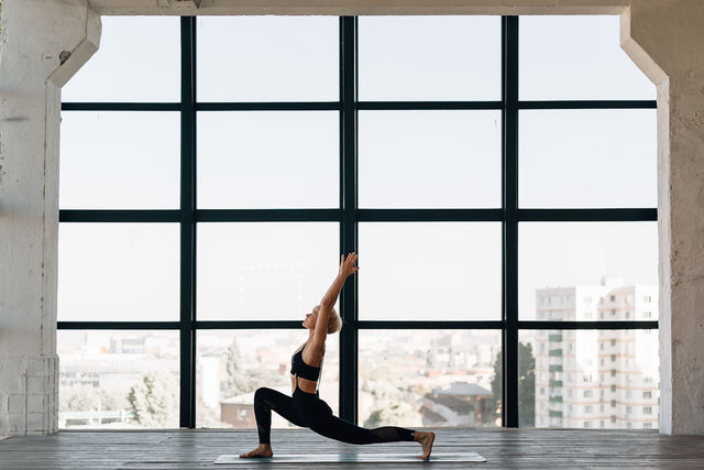 Woman in black activewear doing a stretching pose, representing fitness and weight loss