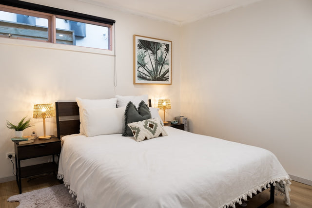 Clean bright bedroom with white bedding and warm ambient lighting