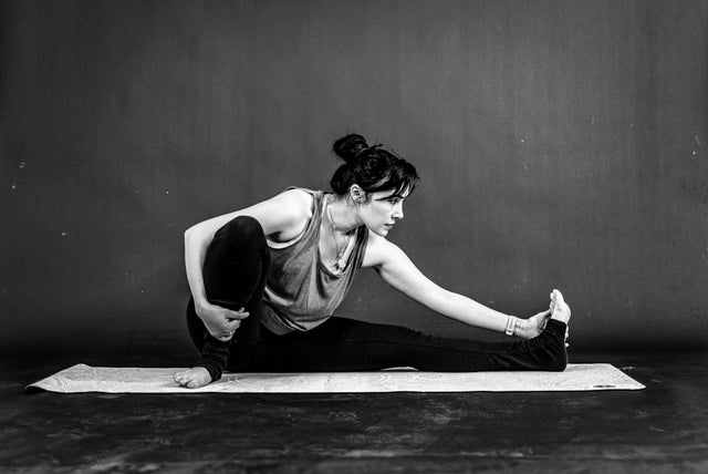Woman doing a yoga pose on a mat, representing fitness and wellness