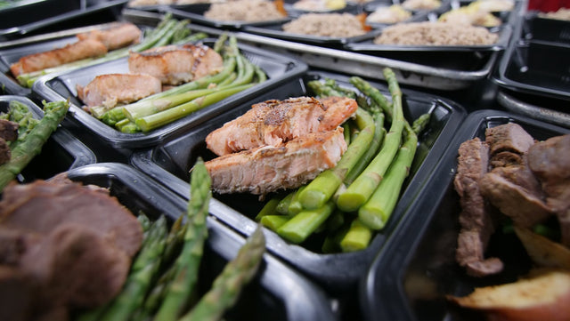 a group of meats and vegetables on a grill