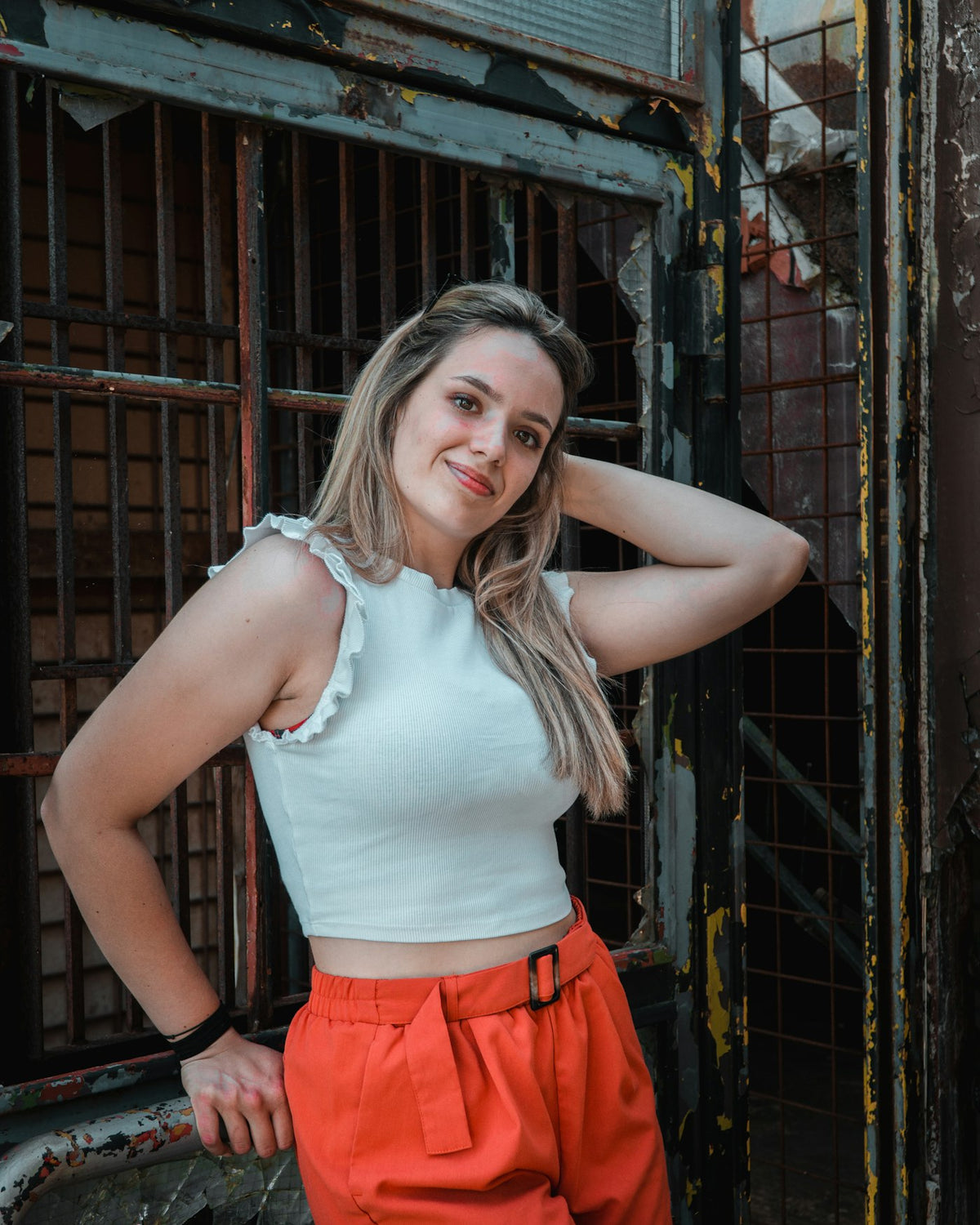 a woman posing for a picture in front of a jail cell
