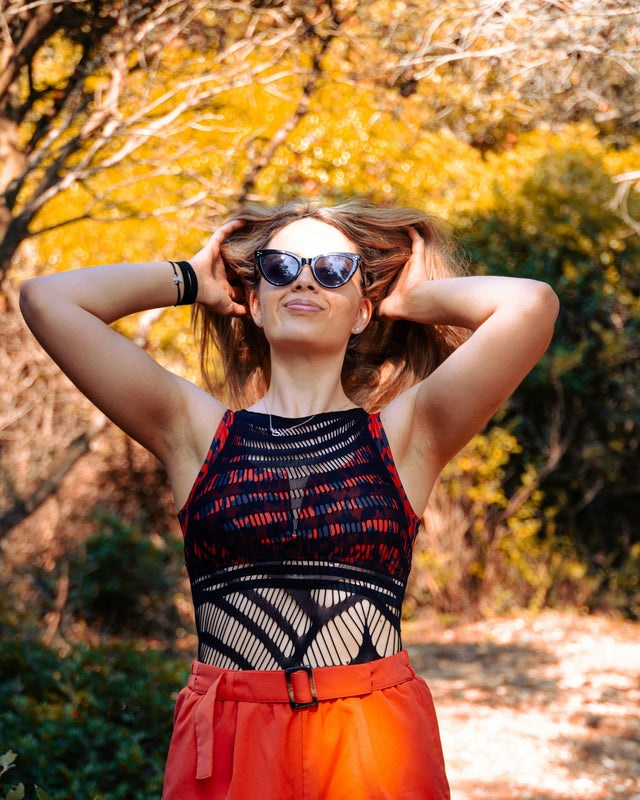 a woman in a red and black top and sunglasses