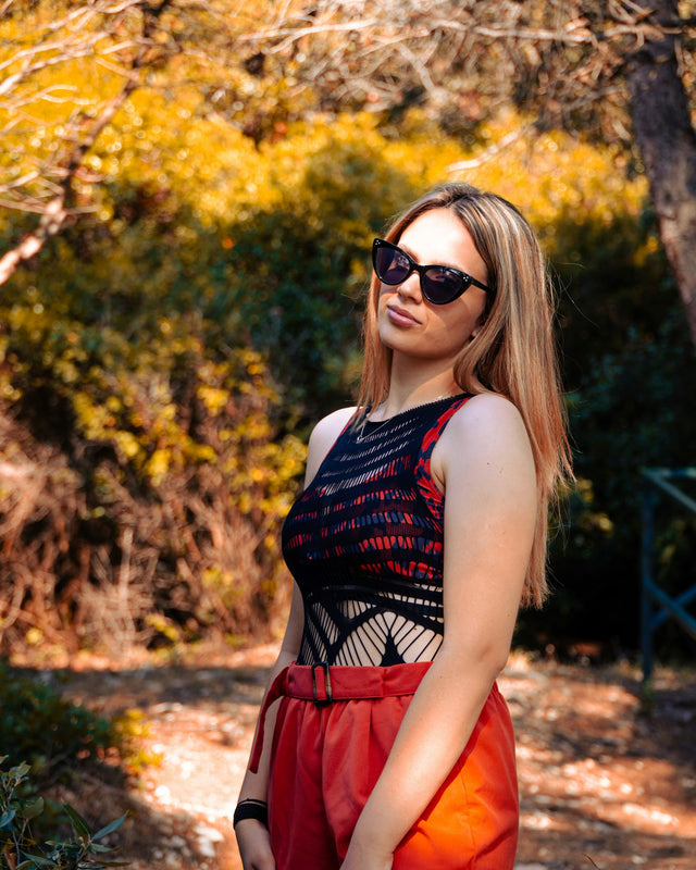 a woman wearing sunglasses standing in the woods