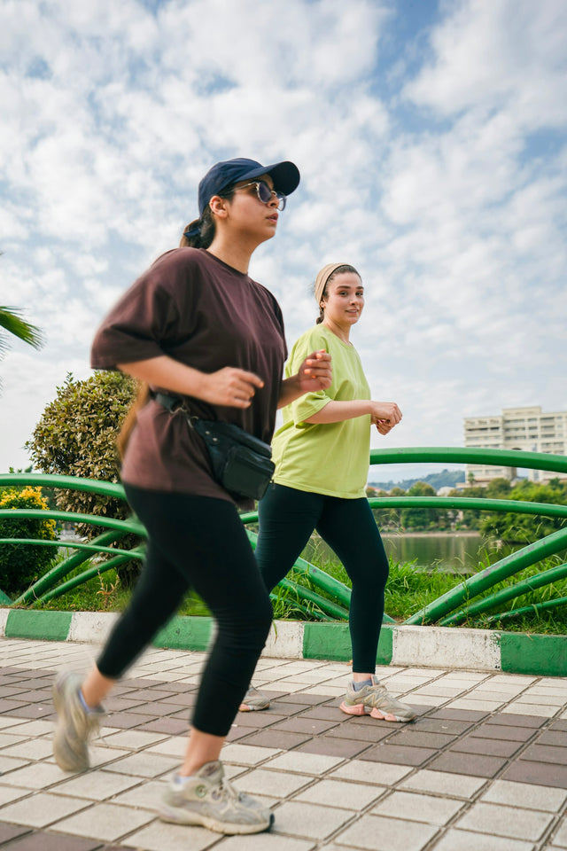 Two women jogging in a sunny park
