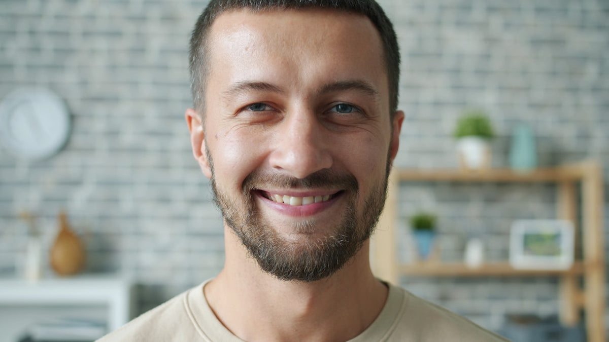 A smiling man with a beard in a casual setting