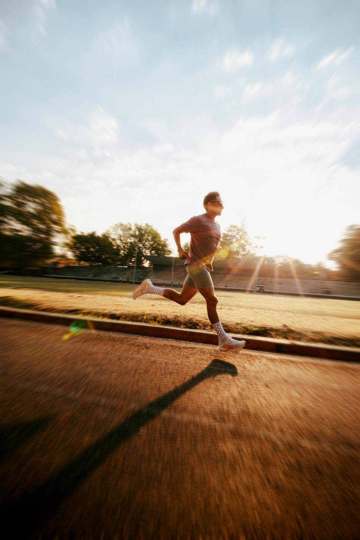 Man running on track at sunrise representing active cardiovascular health and GLP-1 therapy