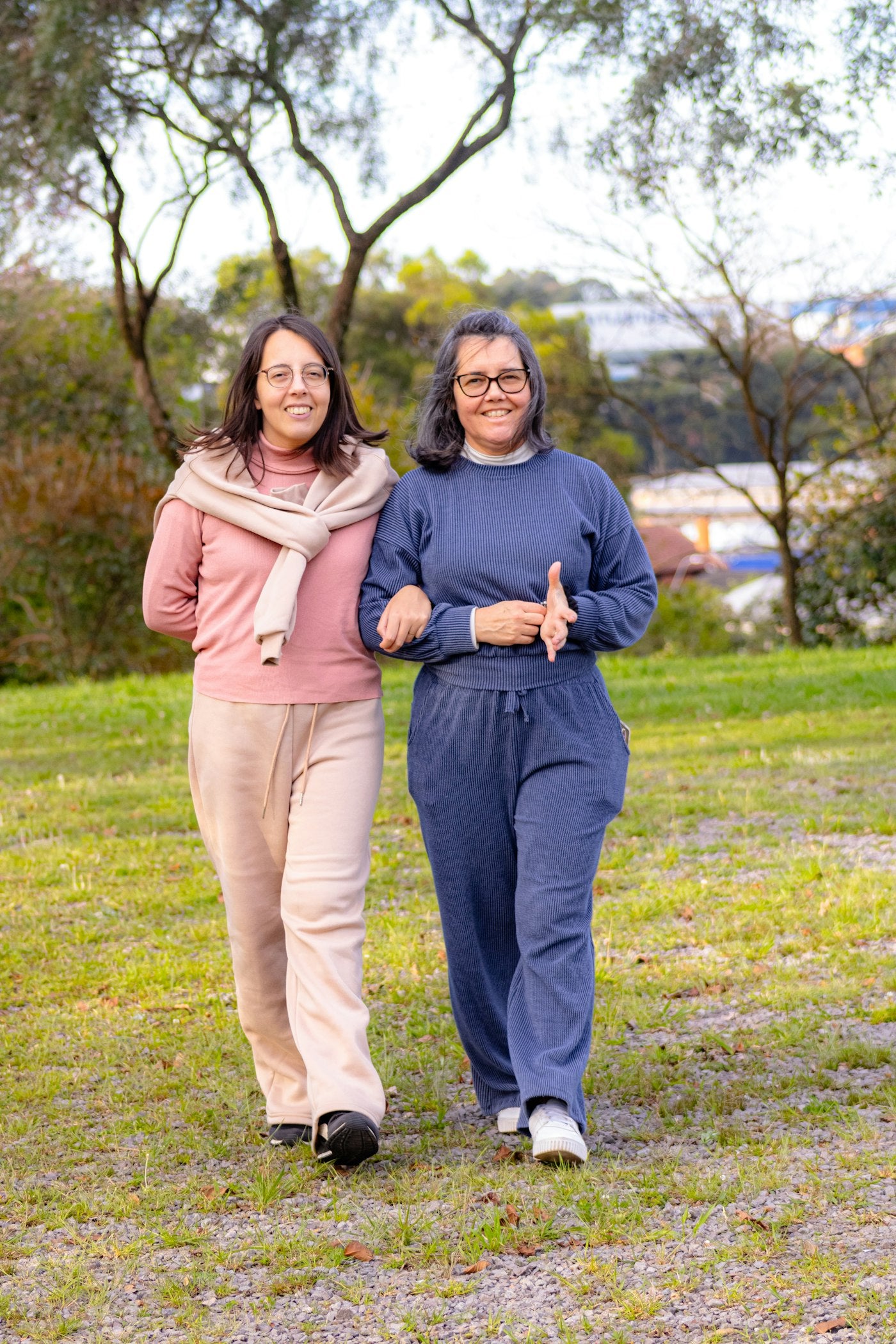 Two women walking together outdoors in a park on a healthy active lifestyle stroll
