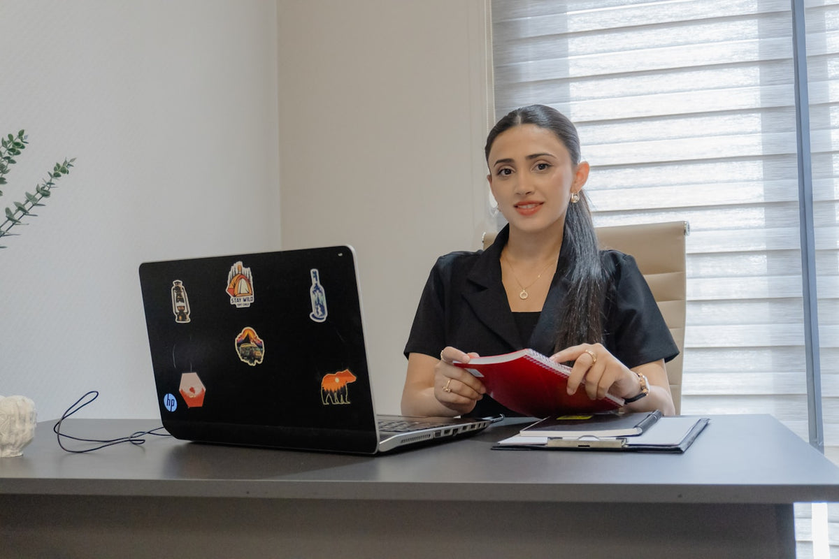 Woman working at a desk with a laptop.