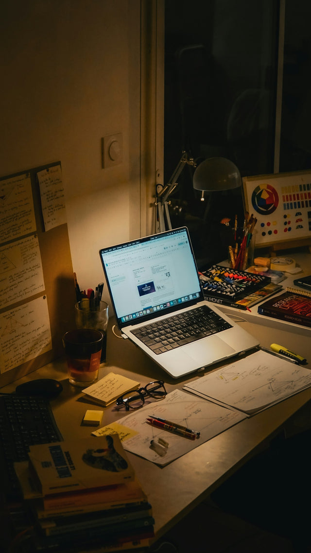 Desk with laptop and notes at night, representing telehealth research