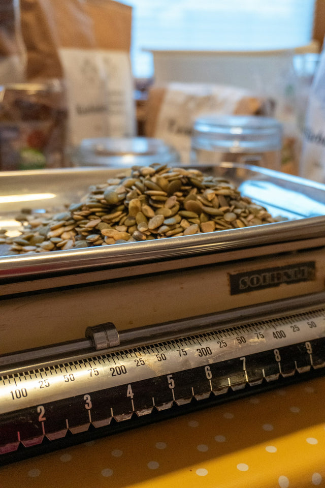 Pumpkin seeds piled on a vintage kitchen scale