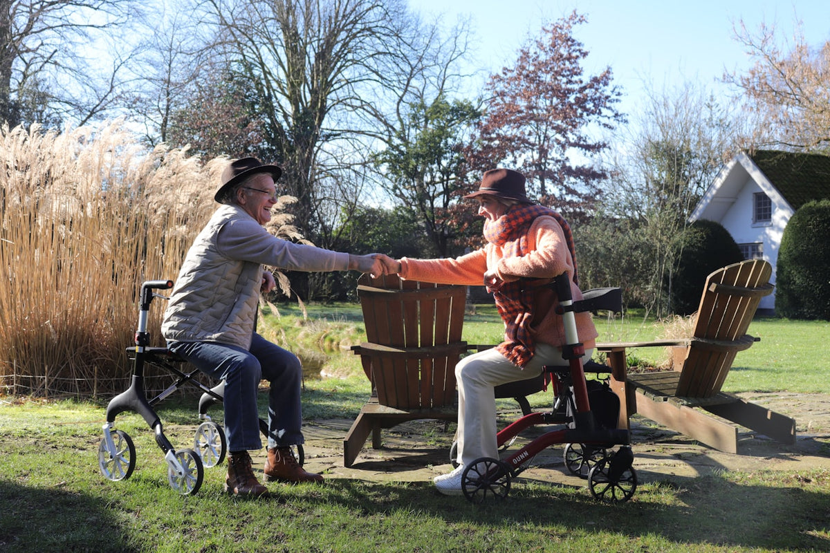 Two people in hats shake hands outdoors.