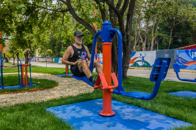A man exercising on outdoor gym equipment in a park.