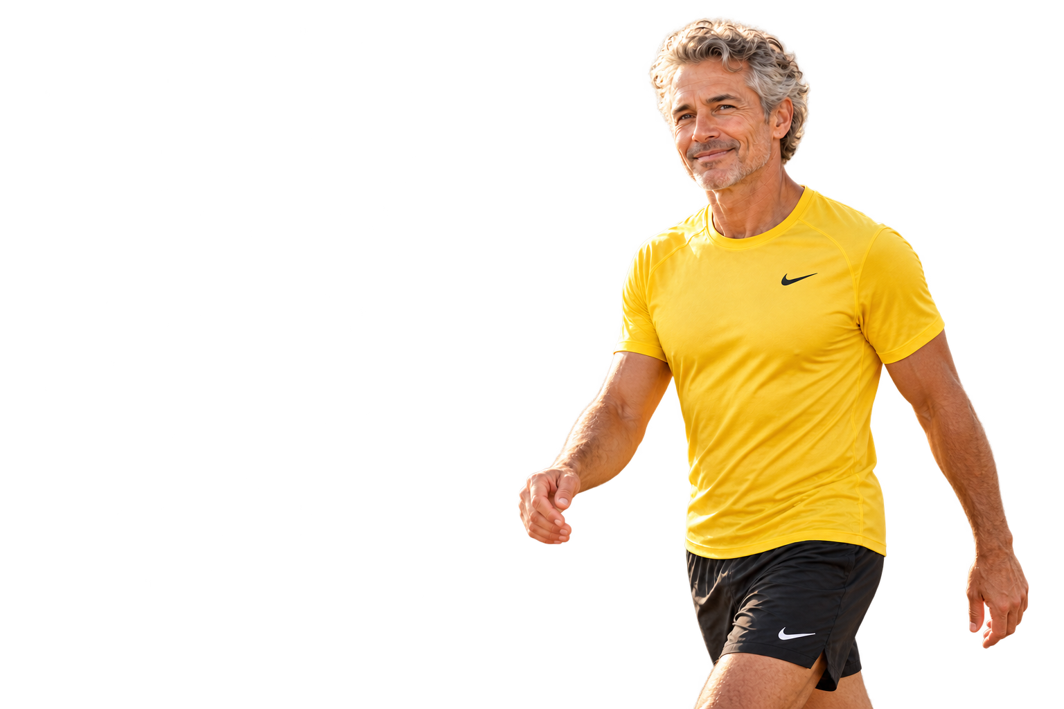 Older man with gray curly hair in a yellow Nike top and black shorts enjoying a coastal walk